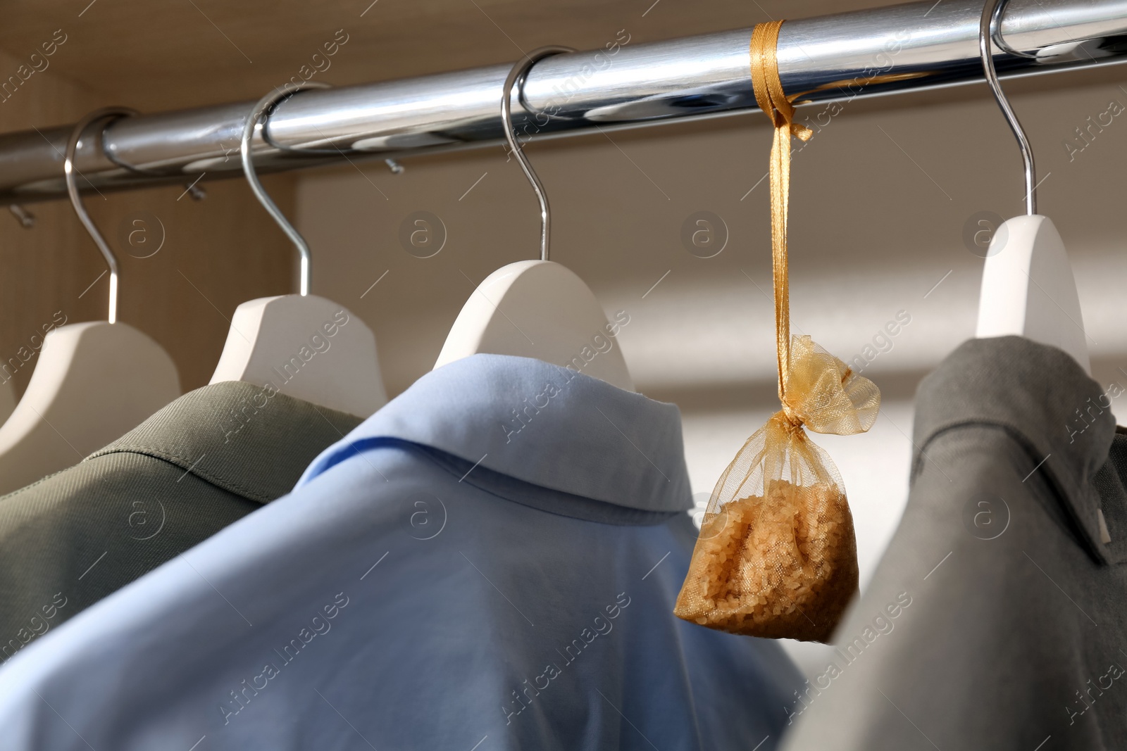 Photo of Scented sachet and clothes hanging in wardrobe