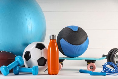 Many different sports equipment on white table