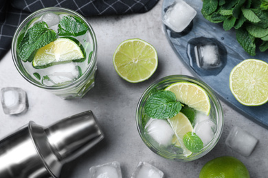 Photo of Glasses of fresh Mojito cocktail on grey table, flat lay