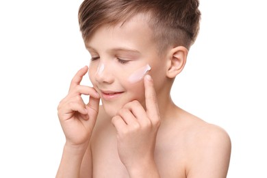 Photo of Happy boy applying sun protection cream onto his face against white background