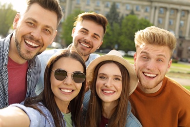 Happy people taking selfie outdoors on sunny day