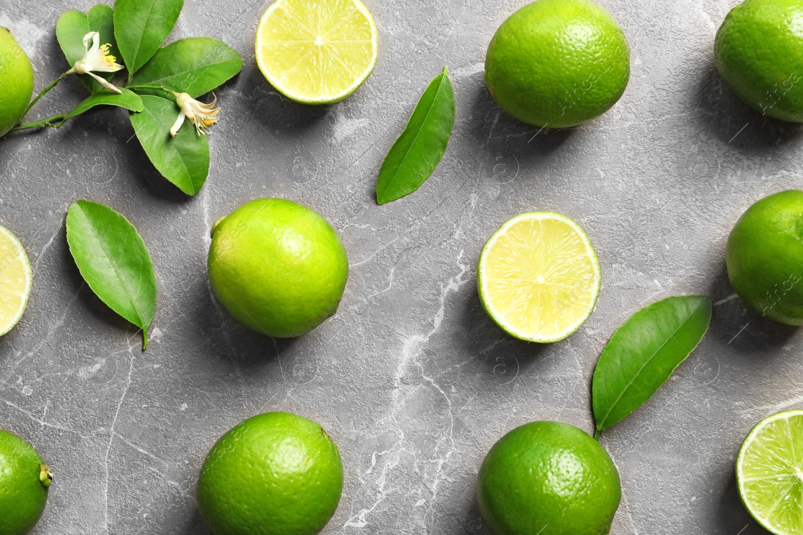 Photo of Flat lay composition with fresh ripe limes on gray background, top view