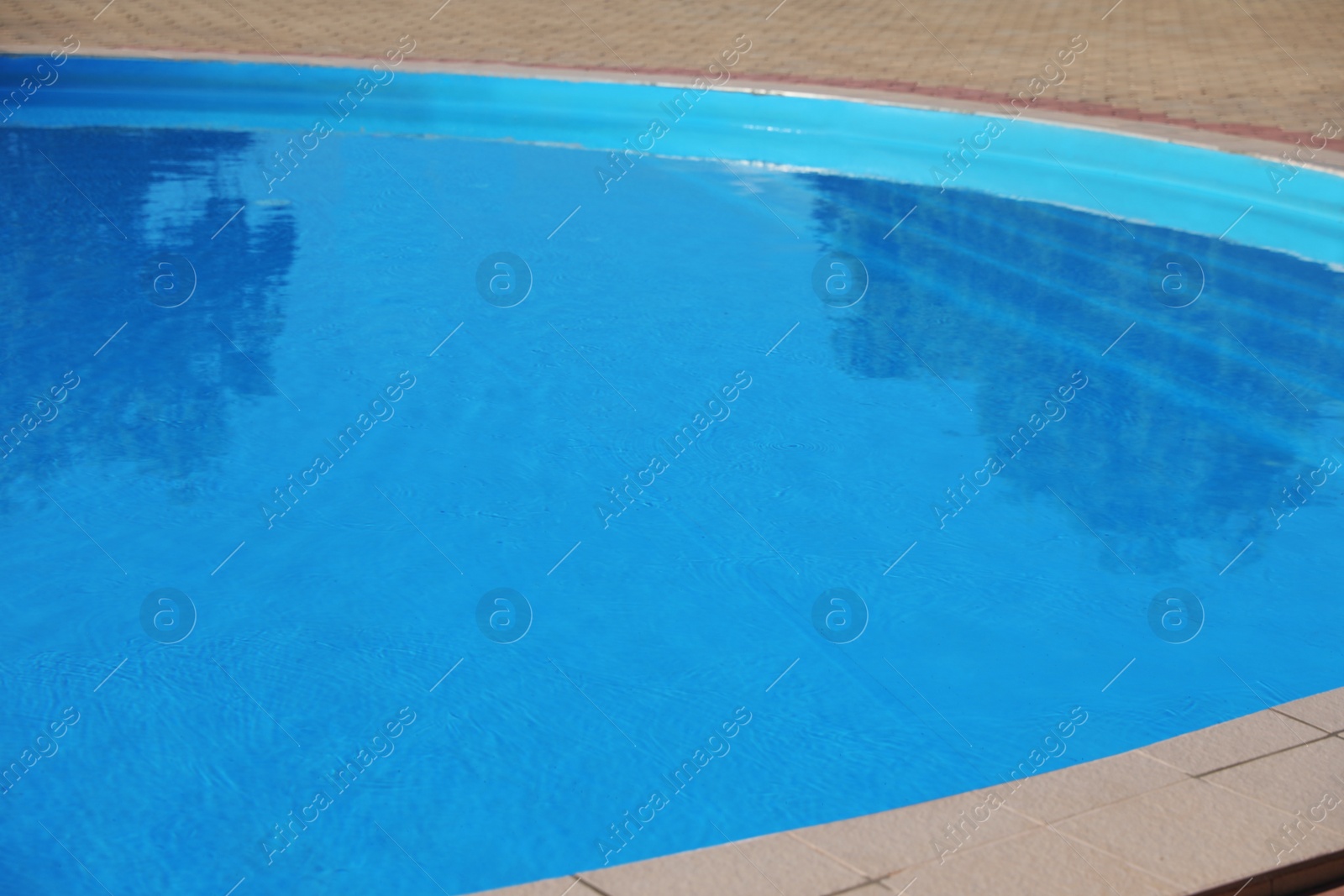 Photo of Outdoor swimming pool with clear water on sunny day. Summer vacation