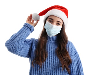 Photo of Beautiful woman wearing Santa Claus hat and medical mask on white background