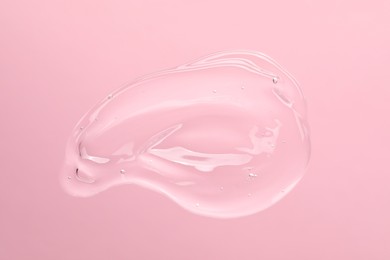 Sample of cleansing gel on light pink background, top view. Cosmetic product