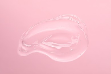 Photo of Sample of cleansing gel on light pink background, top view. Cosmetic product