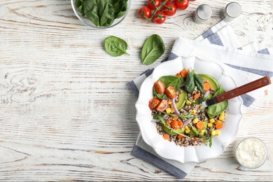 Photo of Healthy quinoa salad with vegetables in plate served on table, top view. Space for text