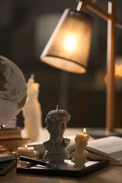 Photo of Beautiful David bust candles on table indoors