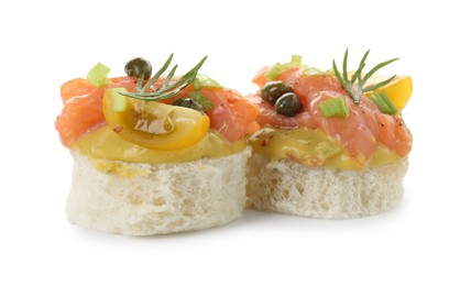 Photo of Tasty canapes with salmon, tomatoes, capers and herbs isolated on white
