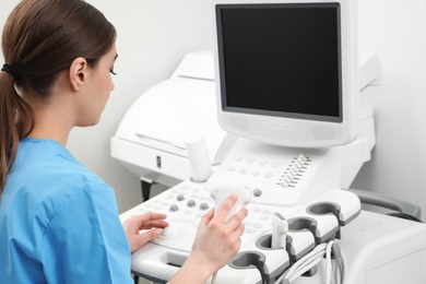 Sonographer operating modern ultrasound machine in clinic