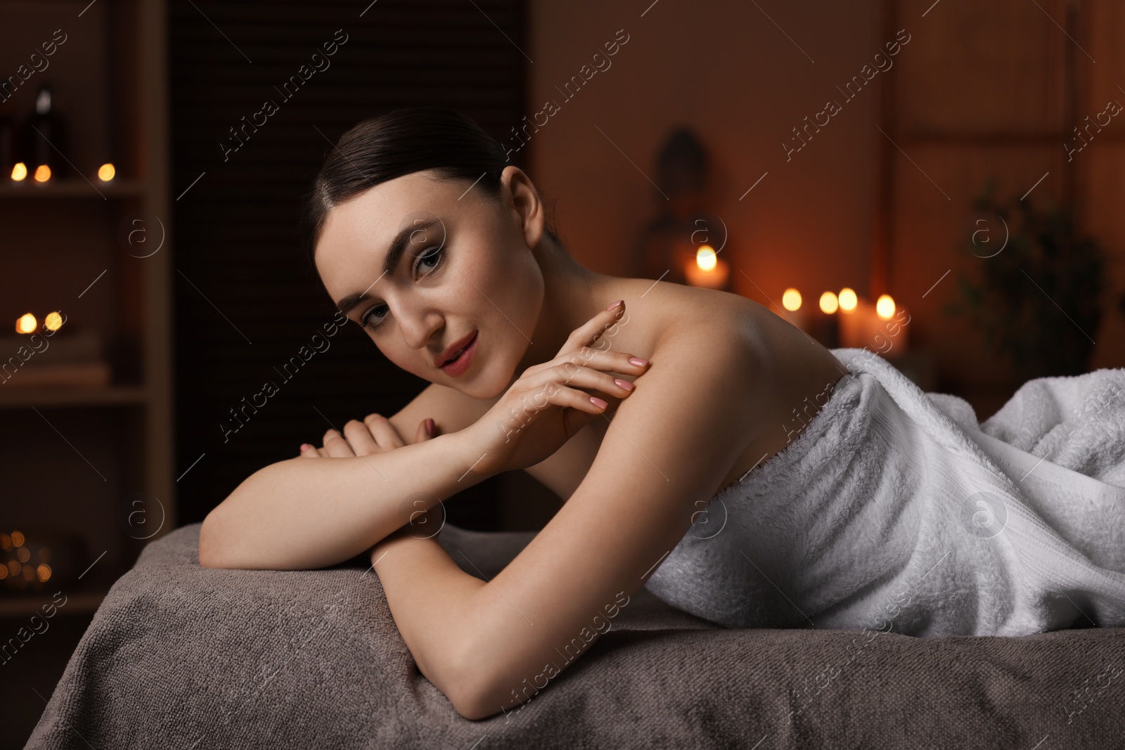 Photo of Spa therapy. Beautiful young woman lying on massage table in salon