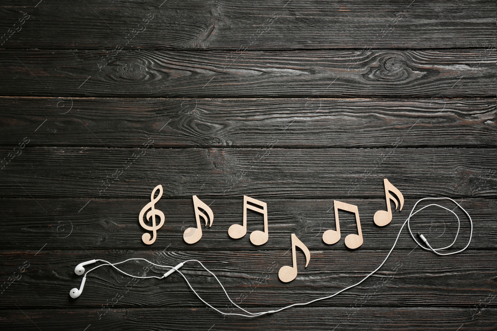 Photo of Flat lay composition with music notes, earphones and space for text on wooden background