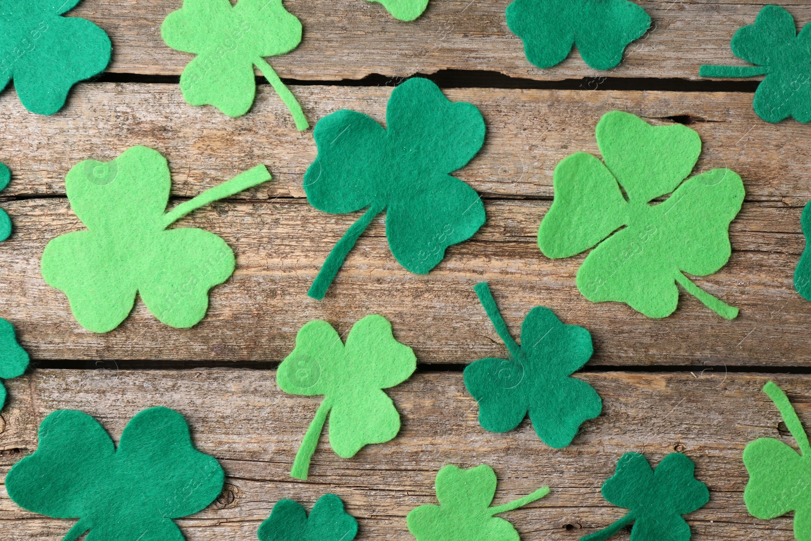 Photo of St. Patrick's day. Decorative clover leaves on wooden background, flat lay