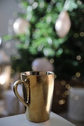 Photo of Golden cup of hot drink indoors. Christmas time