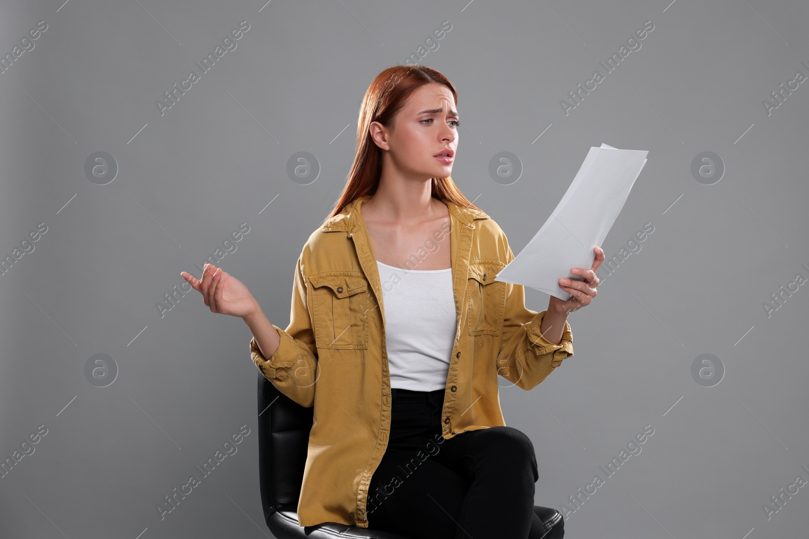 Photo of Casting call. Emotional woman with script performing on grey background