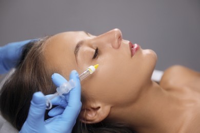 Beautiful woman getting facial injection in salon