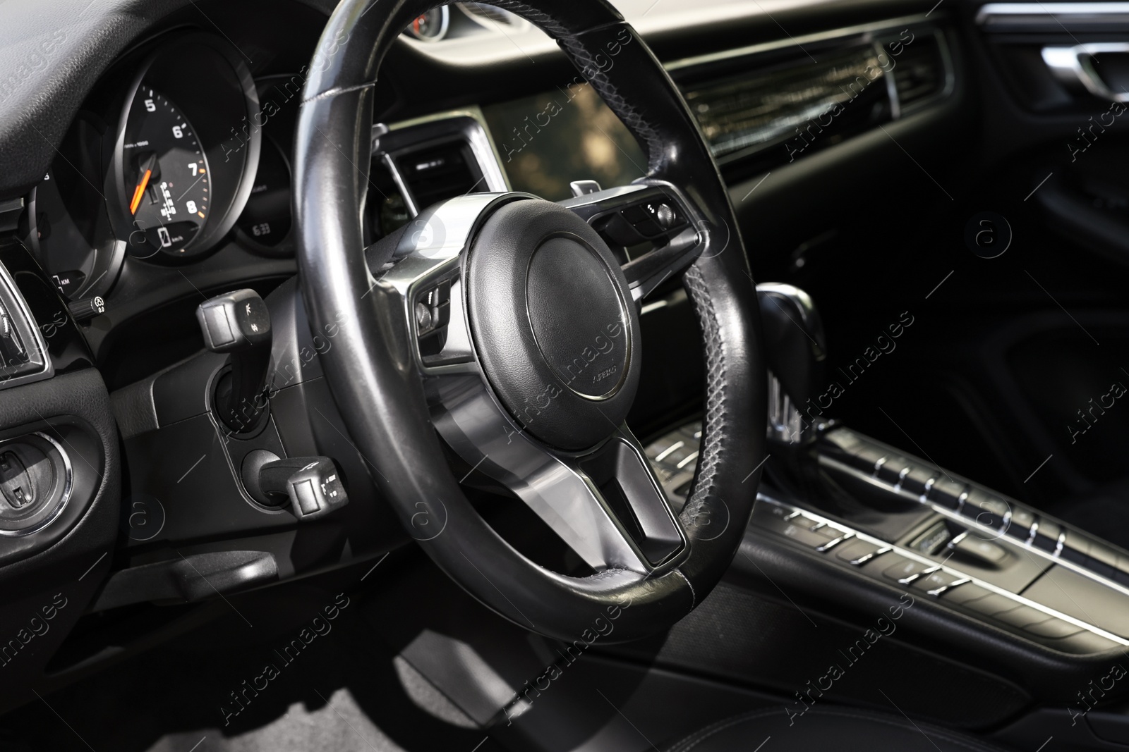 Photo of Steering wheel inside of black modern car, closeup