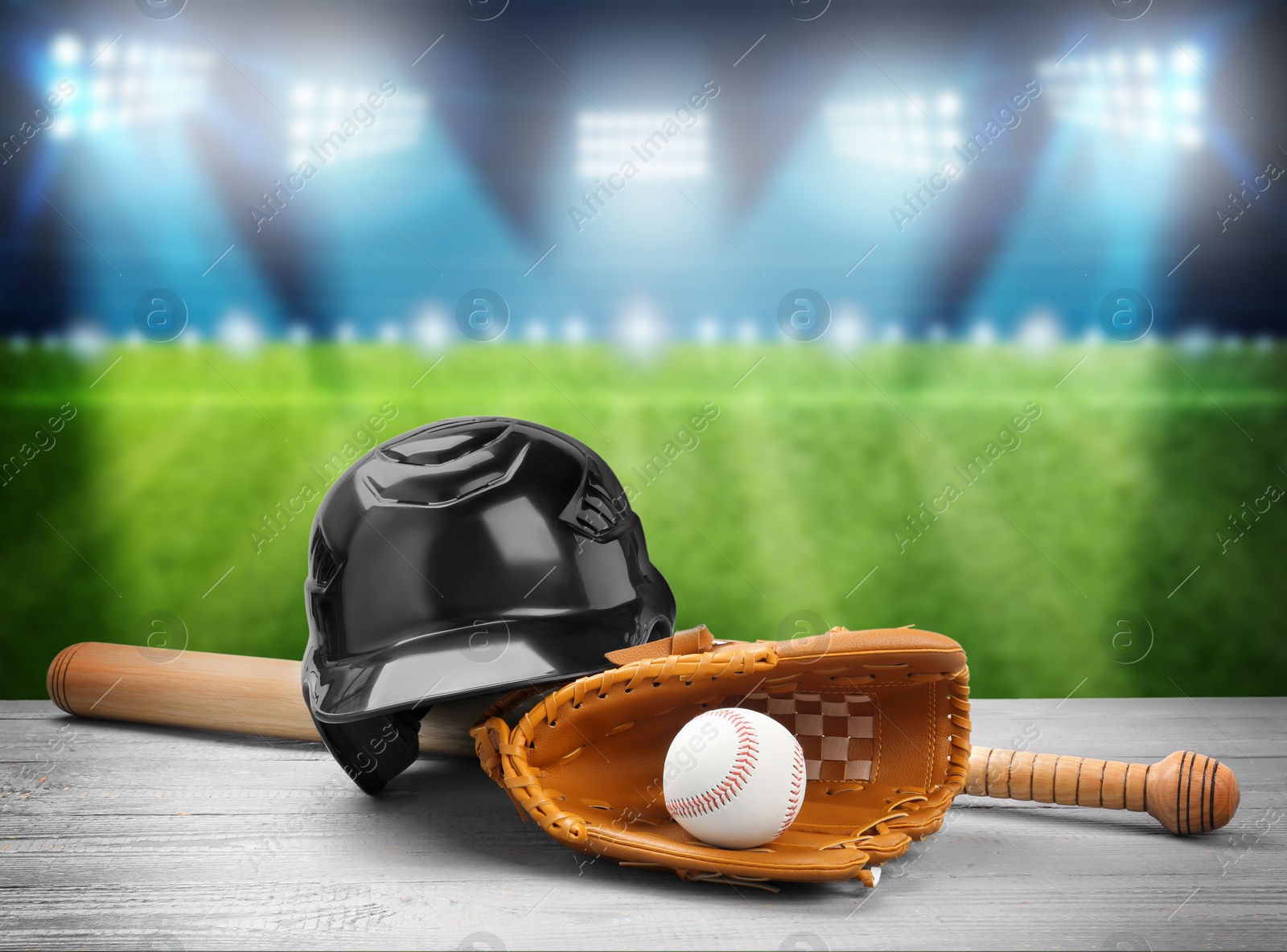 Image of Baseball bat, glove, helmet and ball on wooden table at stadium