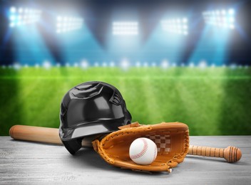 Image of Baseball bat, glove, helmet and ball on wooden table at stadium