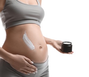 Pregnant woman applying cosmetic product on belly against white background, closeup