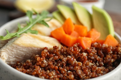 Closeup view of cooked quinoa with garnish in bowl