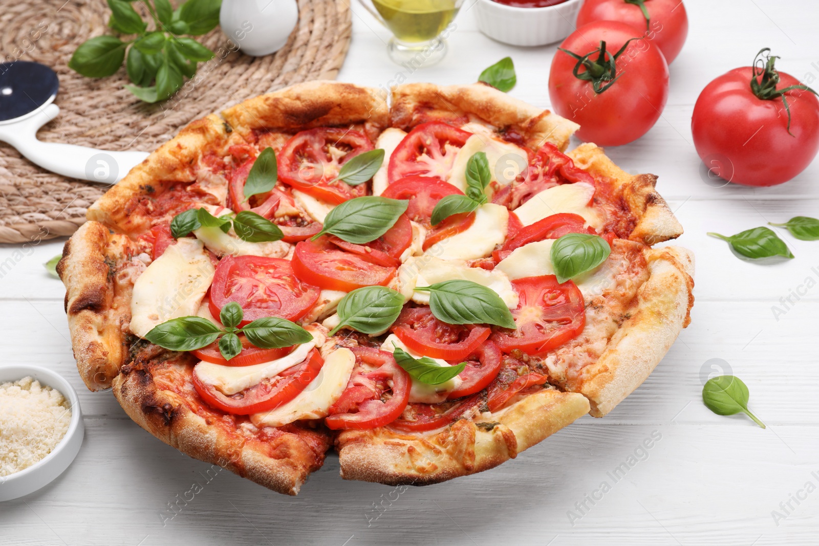 Photo of Delicious Caprese pizza on white wooden table