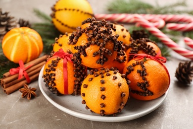 Photo of Pomander balls made of fresh tangerines and cloves grey table