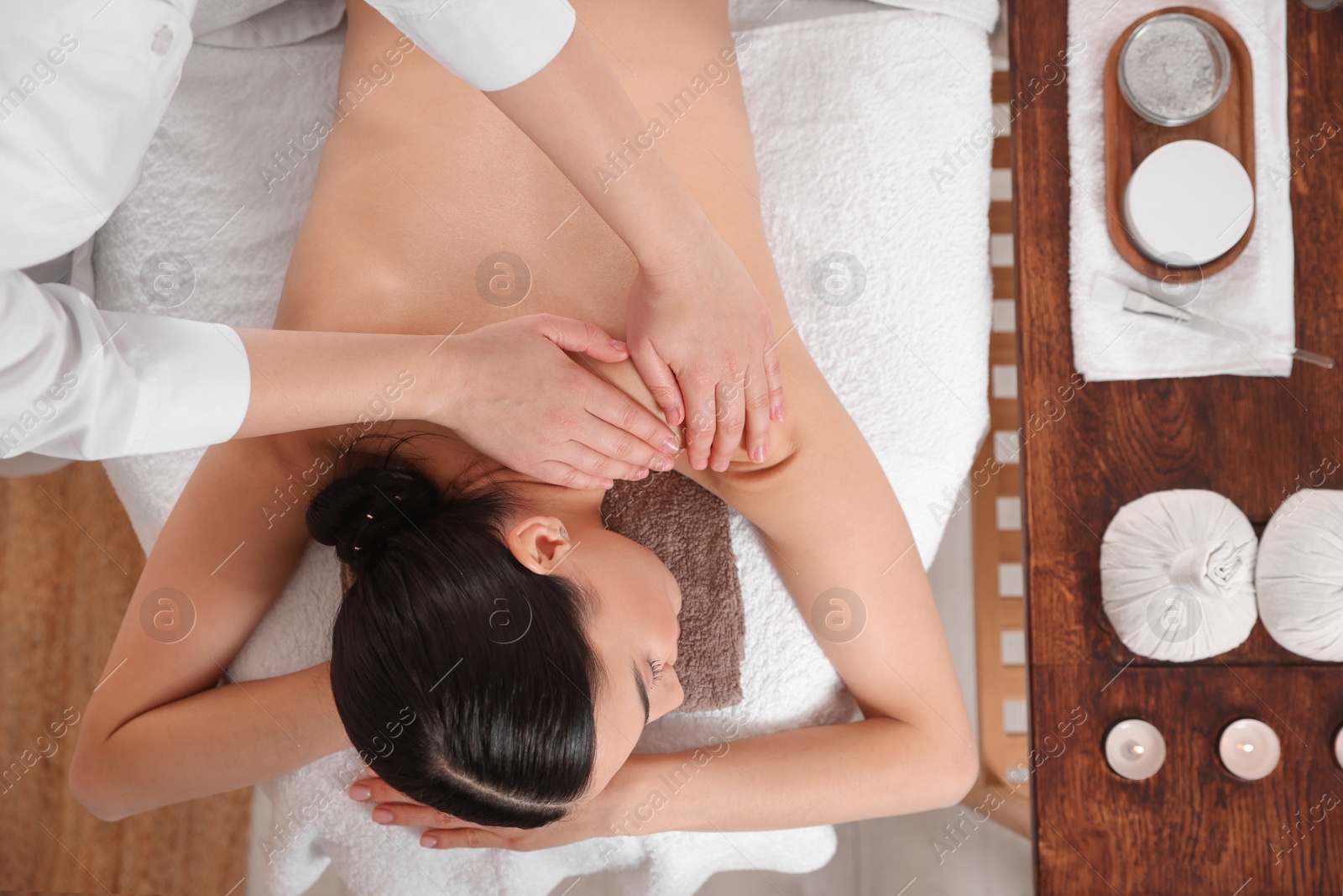 Photo of Young woman having professional massage in spa salon, top view