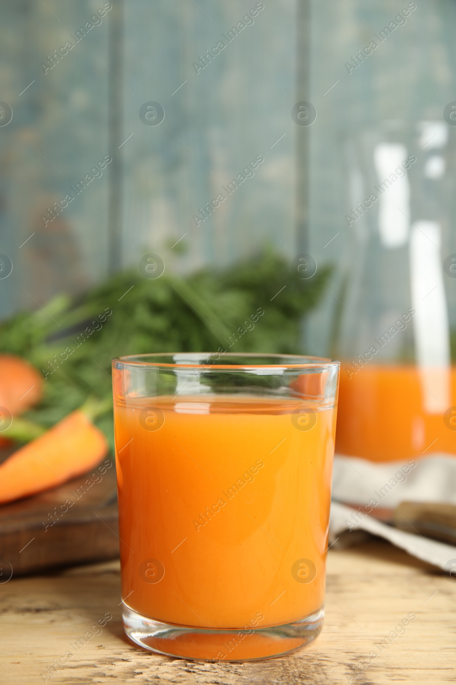 Photo of Glass of freshly made carrot juice on wooden table