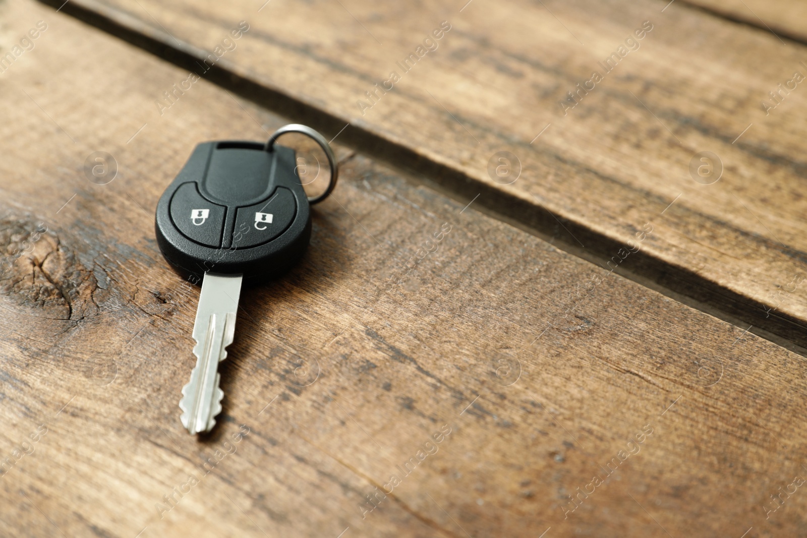 Photo of Car key on wooden background. Space for text