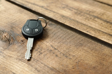 Car key on wooden background. Space for text