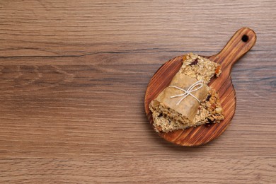 Photo of Tasty granola bars on wooden table, top view. Space for text