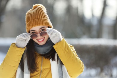 Photo of Portrait of beautiful young woman with sunglasses on winter day outdoors