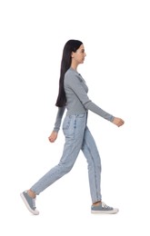 Woman in casual outfit walking on white background