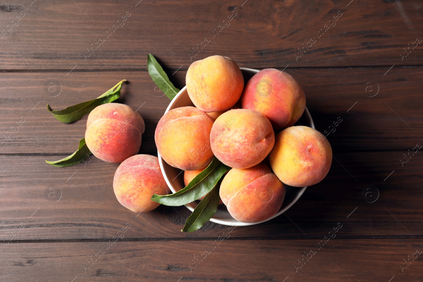 Photo of Plate with fresh sweet peaches on wooden table, top view