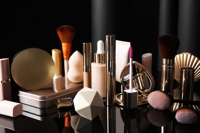 Photo of Composition with makeup products on table against black background