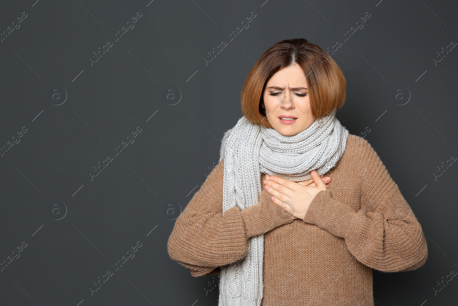 Photo of Woman suffering from cough on dark background. Space for text