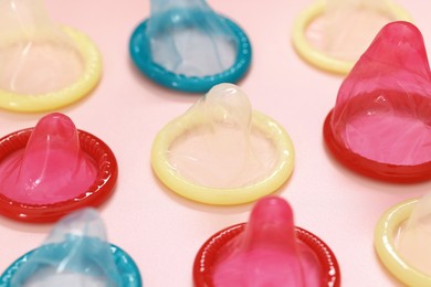 Photo of Condoms on pink background, closeup. Safe sex