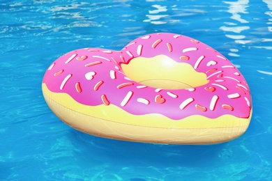 Photo of Heart shaped inflatable heart floating in swimming pool on sunny day