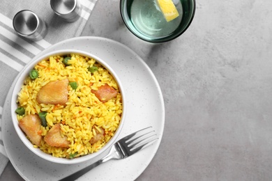 Delicious pilaf with chicken meat served on light grey table, flat lay. Space for text