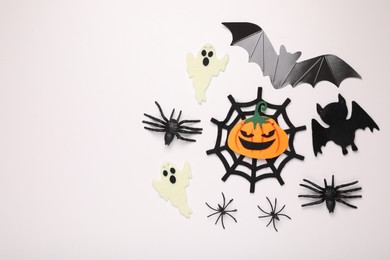 Flat lay composition with Halloween decor on white background, space for text
