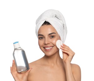 Young woman using cotton pad with micellar water on white background