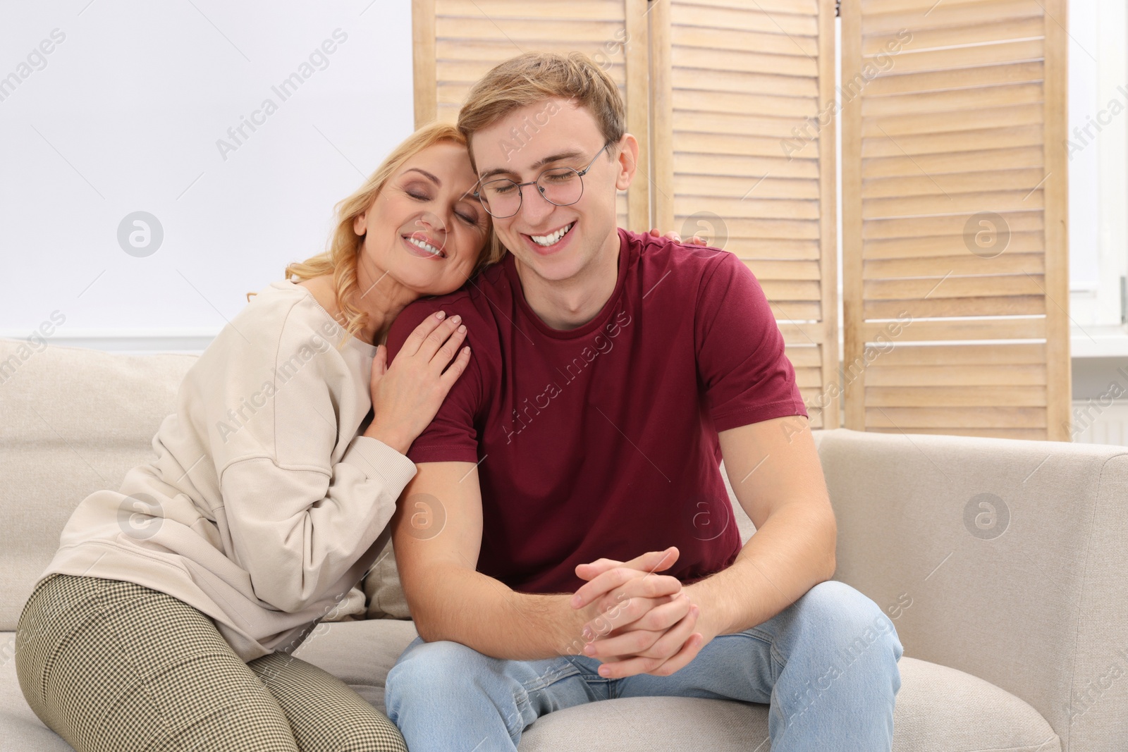 Photo of Mother and son spending time together on sofa at home. Family bonding