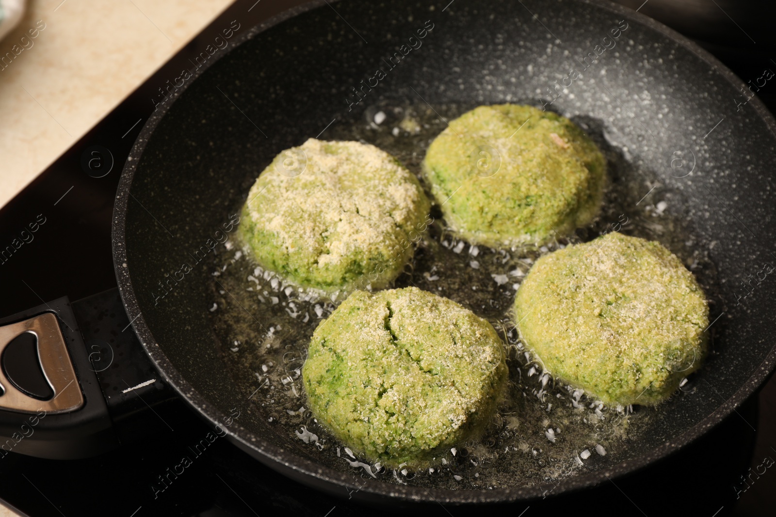 Photo of Cooking vegan cutlets in frying pan on stove, closeup