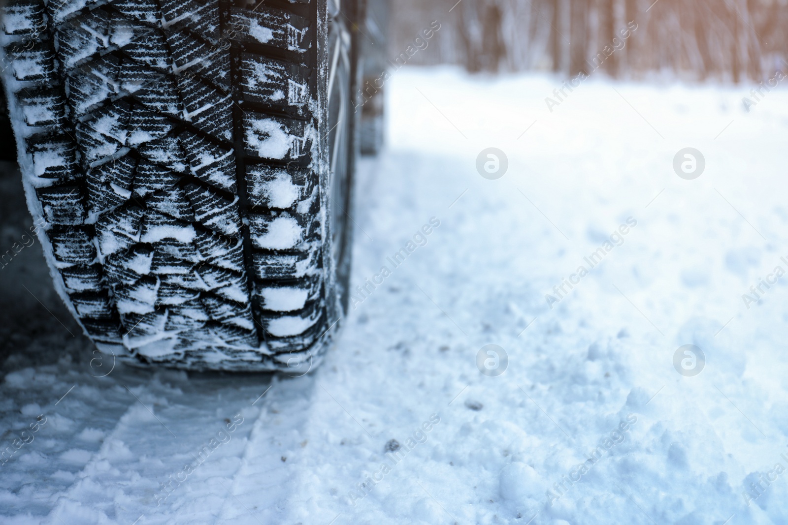 Photo of Snowy country road with car on winter day, closeup. Space for text