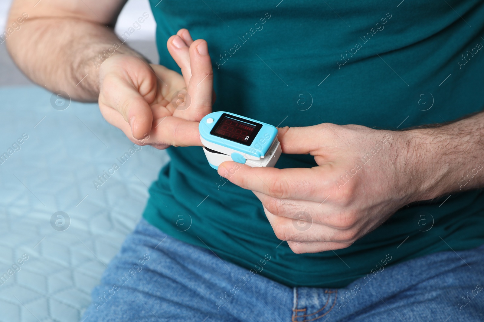 Photo of Young man checking pulse with digital medical device, closeup
