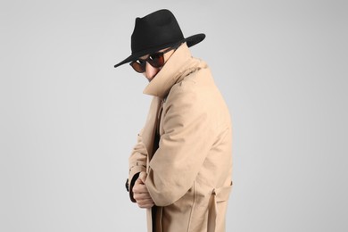 Photo of Exhibitionist in coat and hat on light background