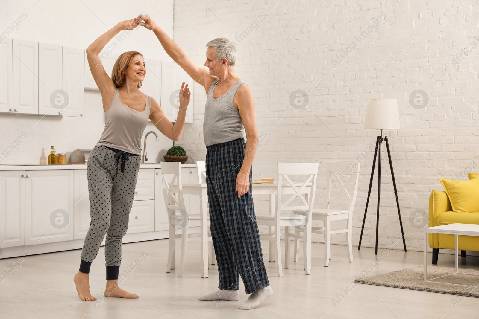 Photo of Happy senior couple dancing together in kitchen