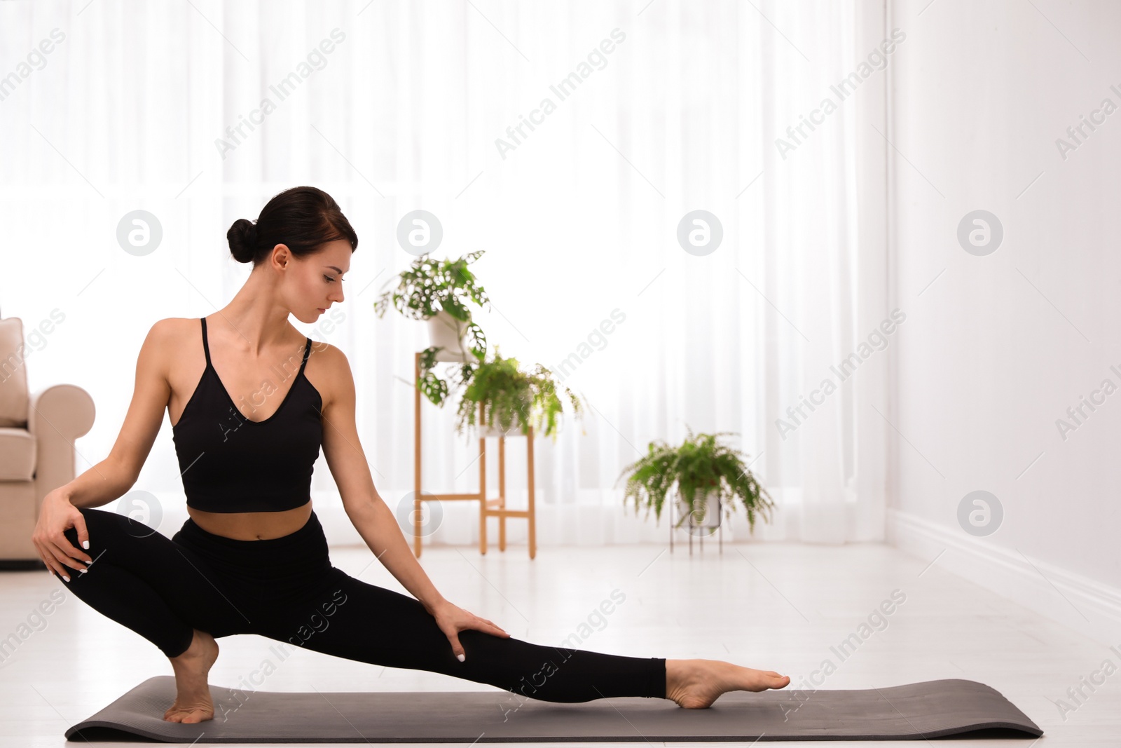 Photo of Professional young acrobat practicing yoga at home