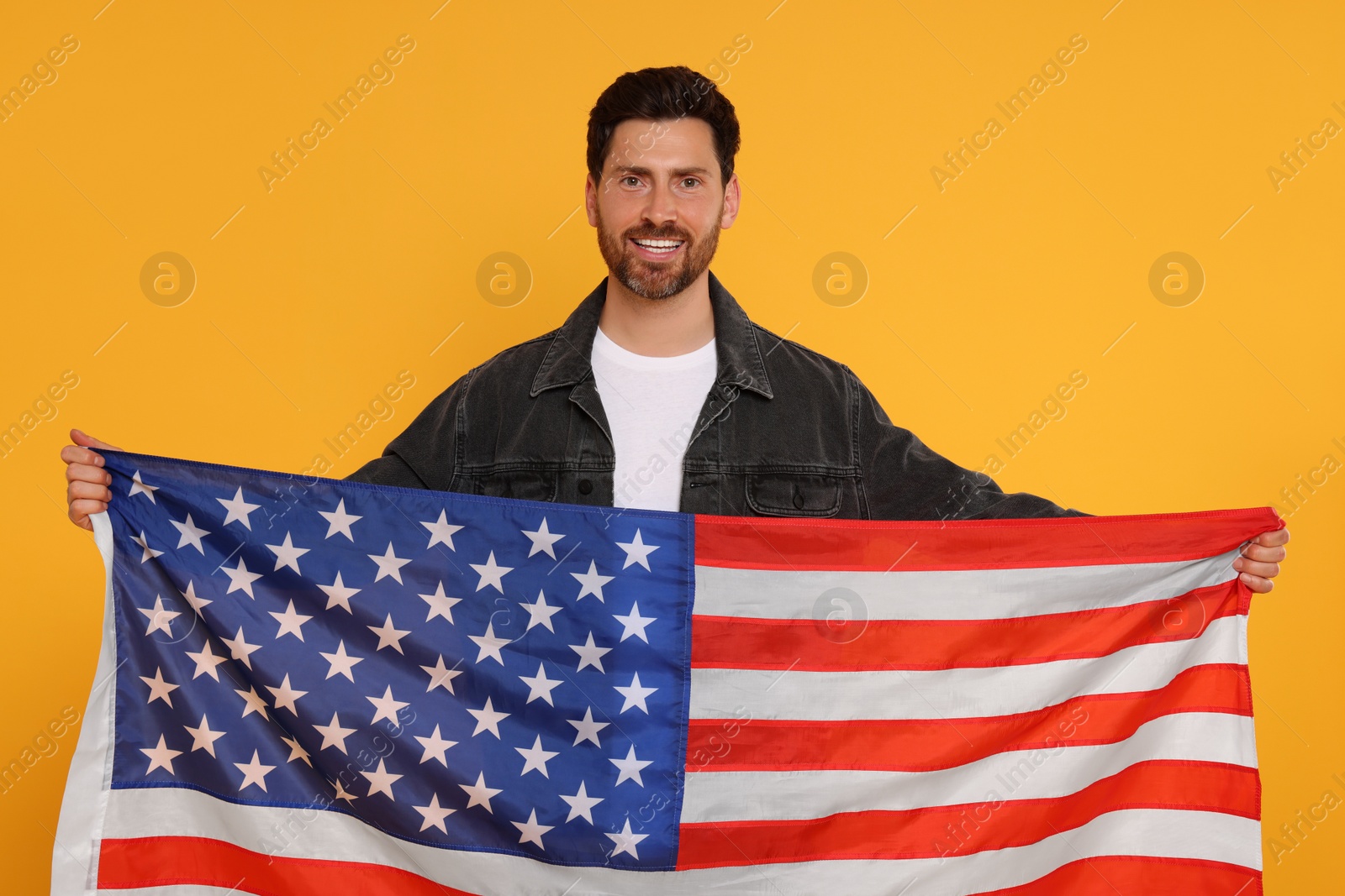 Photo of 4th of July - Independence Day of USA. Happy man with American flag on yellow background